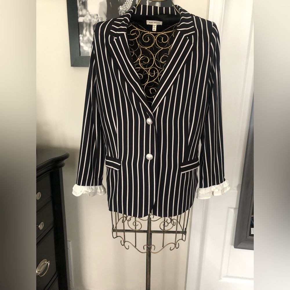 Black and white stripe suit. Blazer has ruffle sleeves.